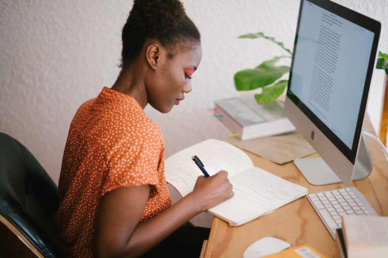 Woman writing in notebook at desk